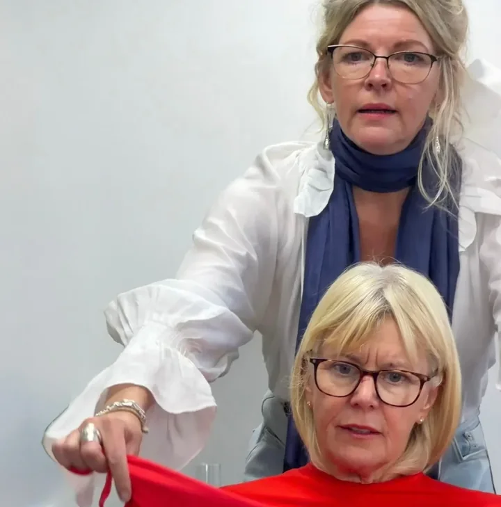 Colour analyst holding a red drape in front of a client